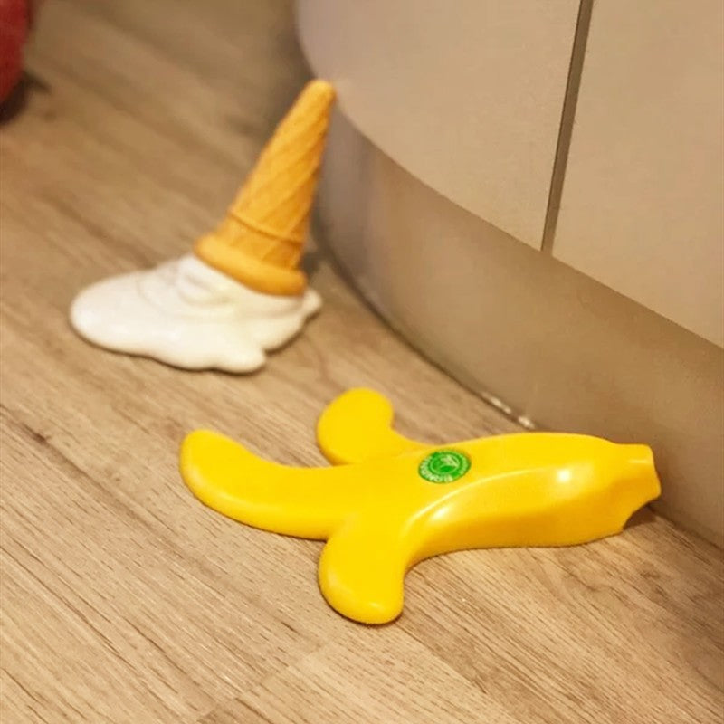 Ice cream and banana door stoppers on a wooden floor