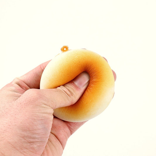 Hand squeezing a golden bun squishy toy