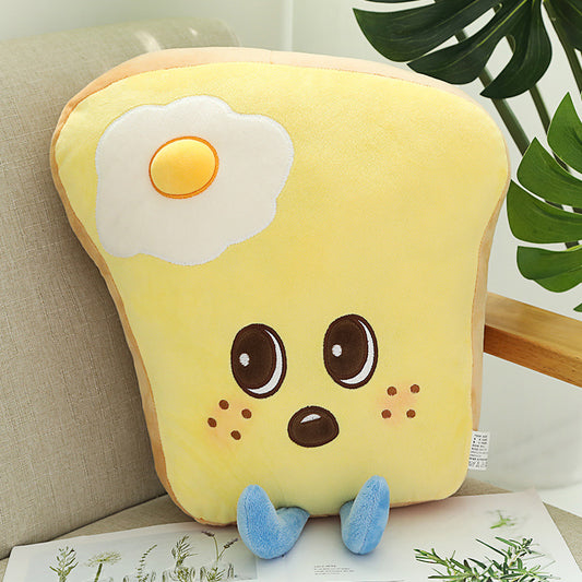 One yellow toast-shaped plush pillow with egg patch, big brown eyes, freckles, beige crust and blue feet.