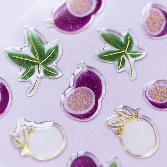 Ten glittery puffy stickers: purple figs and slices, green leaves, and white round fruits with gold accents...