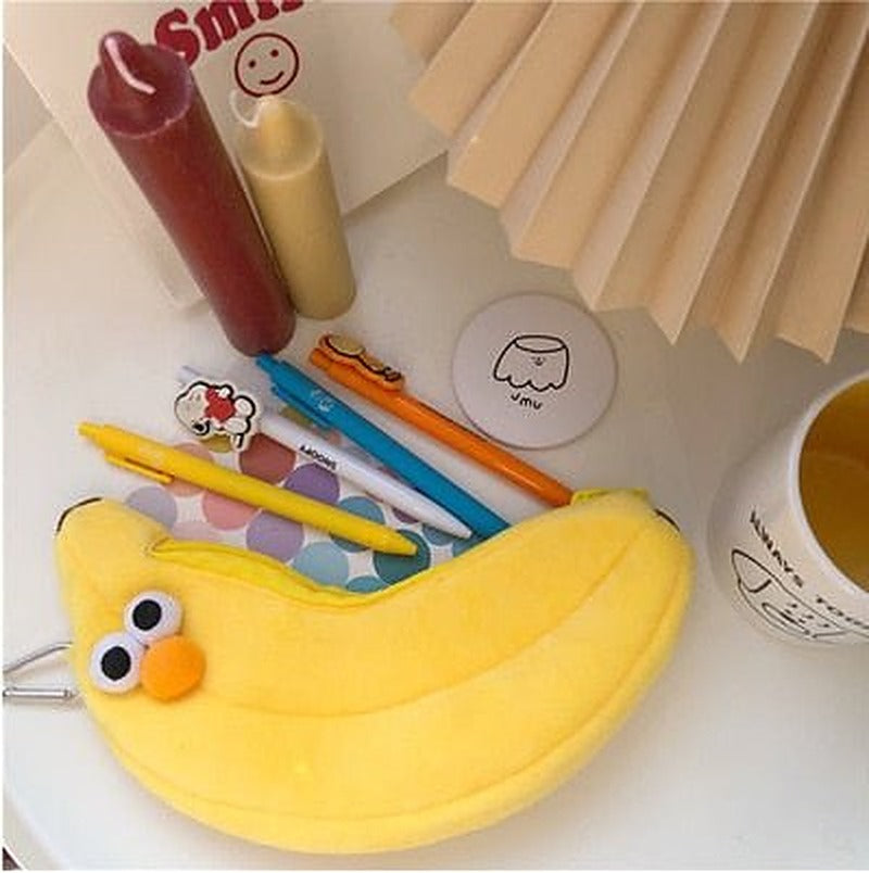 Banana plush pencil case with googly eyes and an orange beak, pens tucked behind