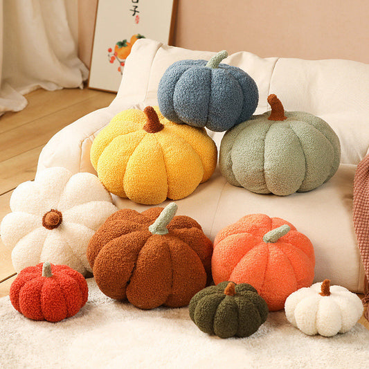 Teddy pumpkin plush cushions in a pile of autumn colours
