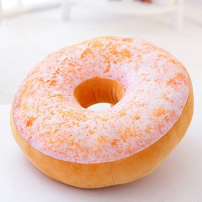 One round plush donut pillow with a pink speckled top, tan bottom, centre hole, soft plush texture.