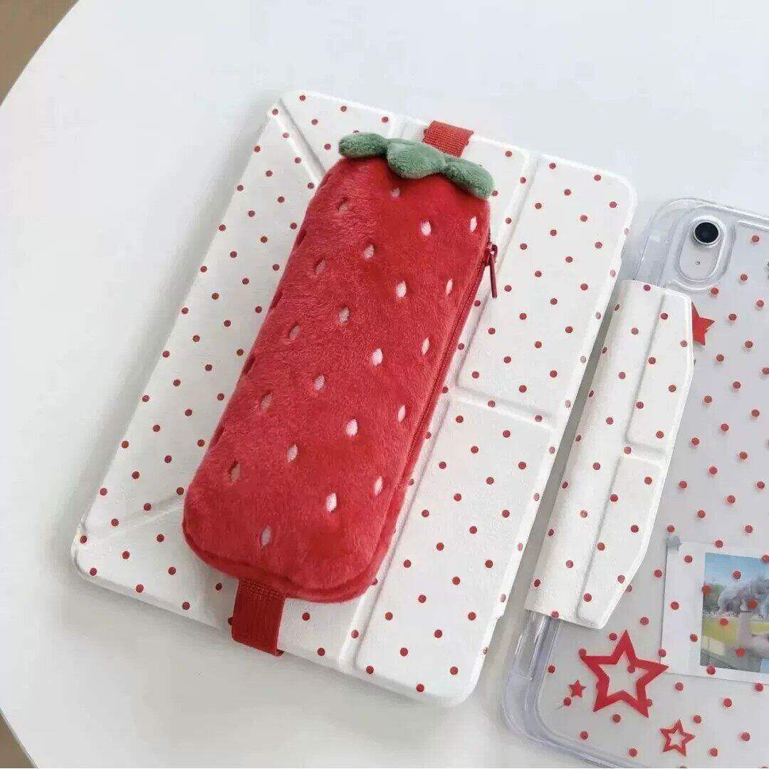 Red strawberry plush pencil case strapped to a tablet cover