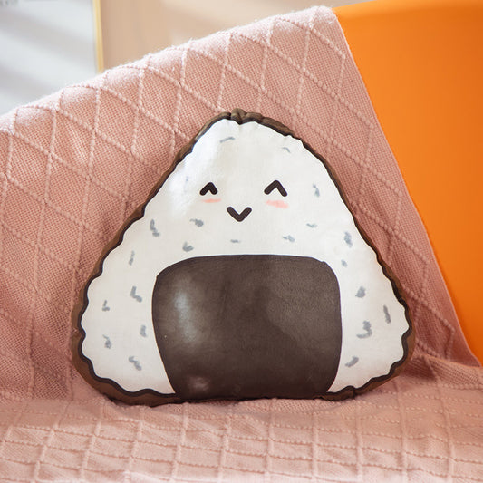 1 triangular onigiri plush, white with gray speckles, smiling face and brown seaweed patch, on a pink blanket.