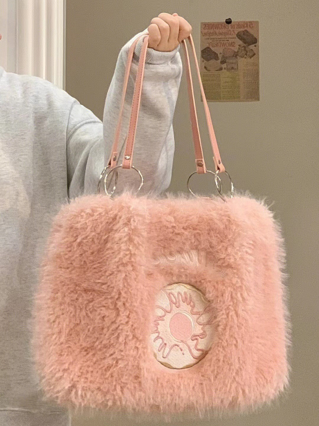Pink fluffy tote bag with donut embroidery on the front, two pink straps, and silver ring attachments.