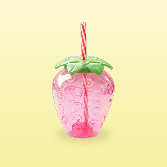 Pink strawberry shaped water bottle with a green leaf lid and striped straw, on a butter yellow background