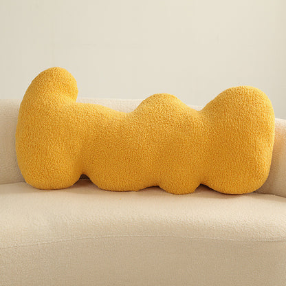 Single yellow teddy-textured knotted cushion with bulbous segments resting on a cream sofa.