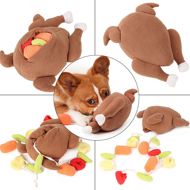 One brown plush roast-shaped dog toy with white-tipped legs and colorful stuffed veg pieces, corgi sniffing
