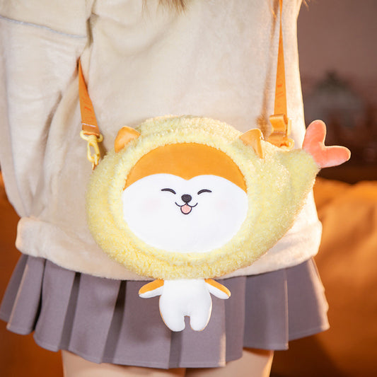 Yellow fuzzy round crossbody bag with smiling white face, orange ears, tiny white body, orange strap.