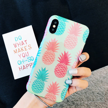 Hand holding one phone with a mint-green silicone case patterned with pink and teal pineapples.