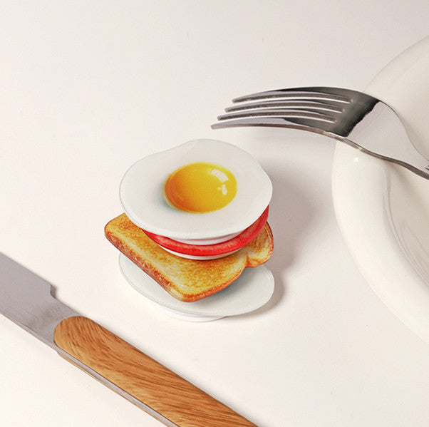 Fried egg and tomato phone grips stacked like a breakfast sandwich