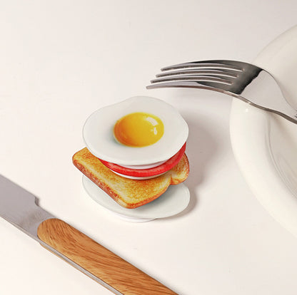 Fried egg and tomato phone grips stacked like a breakfast sandwich