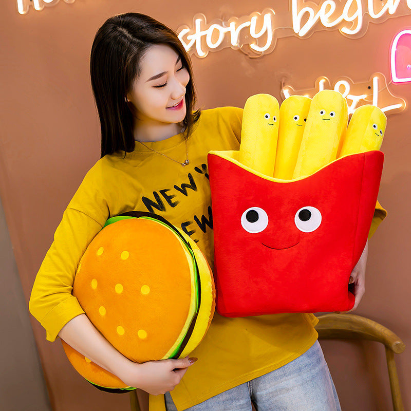 Two plush pillows: red smiling fries box with four yellow smiling fries and a round orange burger pillow.