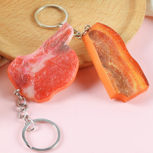 Two meat-shaped keychains — one pink-red marbled, one orange-brown — each with silver ring and chain.