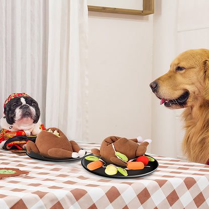 Two brown plush roast toys with fabric carrots and veggies on black plates on a beige checkered table.