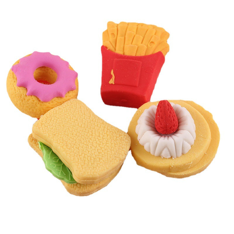 Four food erasers: pink donut; red fries carton; sandwich w/ green lettuce; tart with red strawberry.