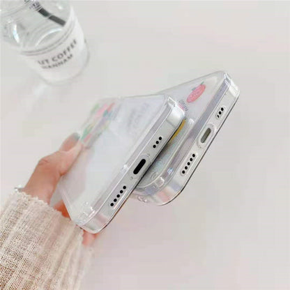 Hand holding two slim clear smartphones with transparent cases stacked, one showing a small strawberry decal.