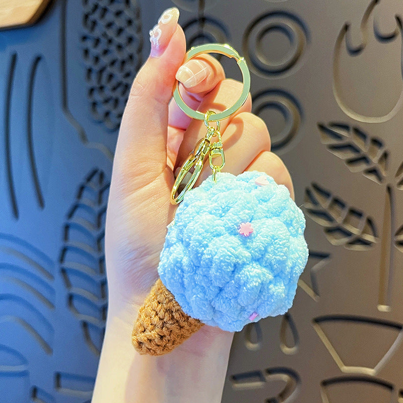 Plush ice-cream keychain with a blue fluffy scoop, pink star sprinkles, brown crocheted cone and gold ring.