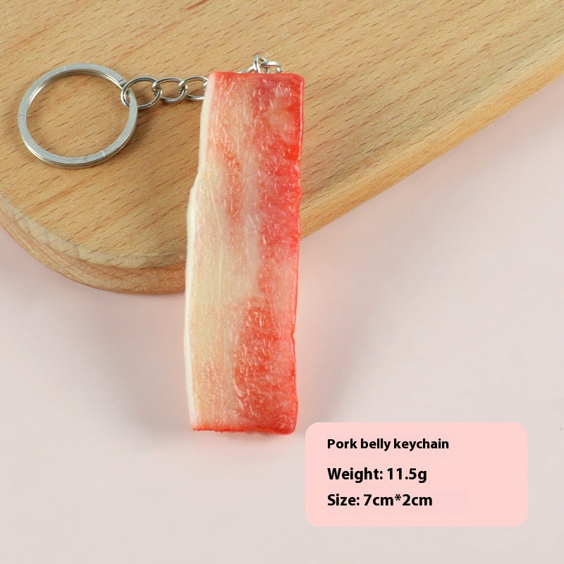 One pork-belly-style keychain, cream and pink-red marbled rectangular strip attached to a silver keyring on...