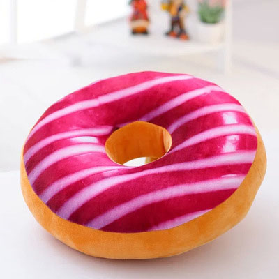 One round donut-shaped plush pillow with bright pink frosting and white stripes, tan dough base.