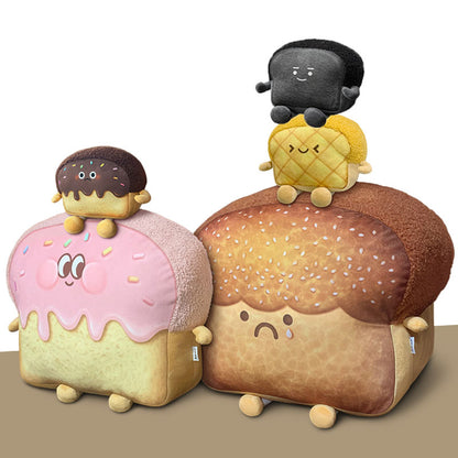 Five plush bread toys: two large loaves (pink smiling with sprinkles, brown sad) topped by three small buns.