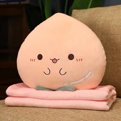 Peach plush pillow sitting on its folded pink blanket