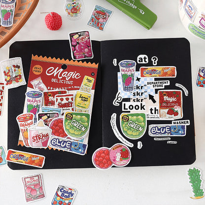 One open black notebook with a 'Magic Delicious' sticker sheet and many colorful food-themed stickers.