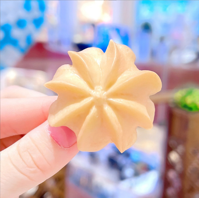 Flower cookie hair clip held in a hand