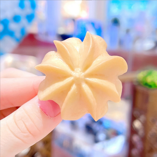 Flower cookie hair clip held in a hand