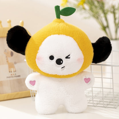 One plush with white body, yellow fruit head and green leaf, winking face, black ears and pink heart patches.