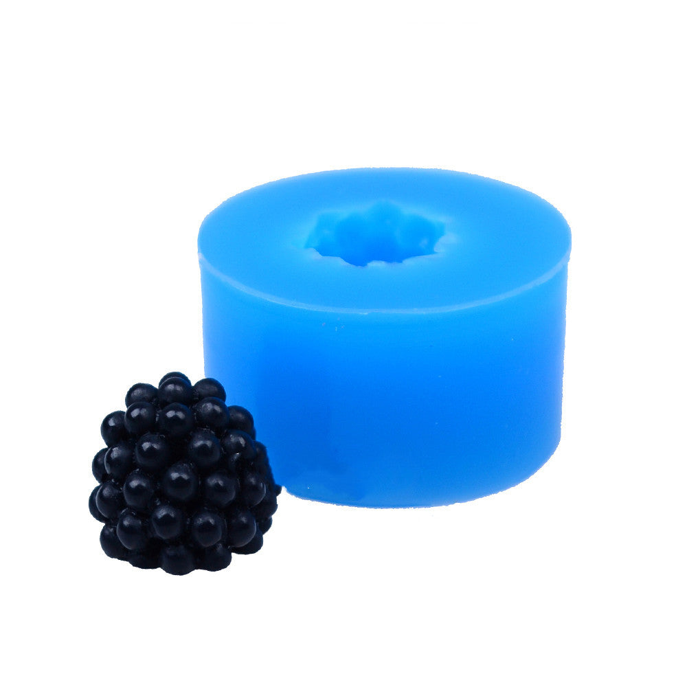 One round blue silicone mold with a star-shaped cavity and one small black bumpy berry-shaped piece.