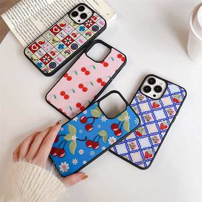 Four iPhone cases displayed, featuring cherry blossom, floral, and cherry patterns in vibrant pastel colours.