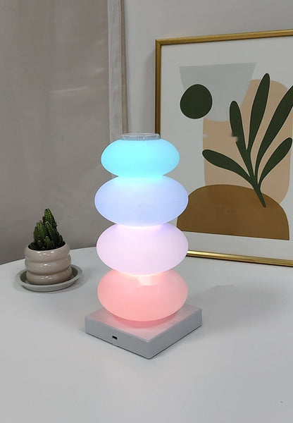 Rainbow candy skewer lamp glowing on a white table