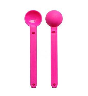 Two bright pink scoop-shaped plastic clips with long handles, one showing an open bowl, one with a rounded ...