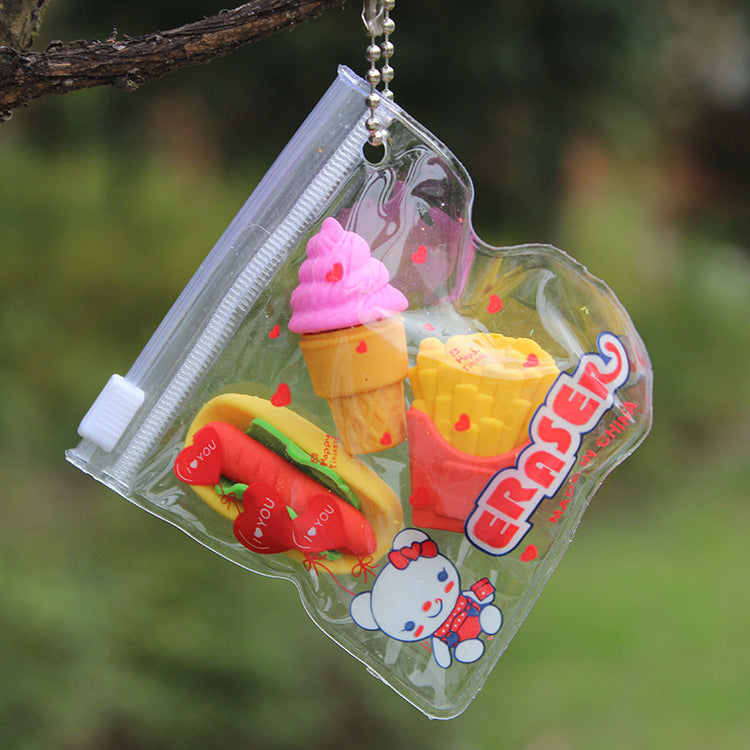 Clear zip pouch with ball chain holding three erasers: pink ice cream cone, red fries, red hot dog.