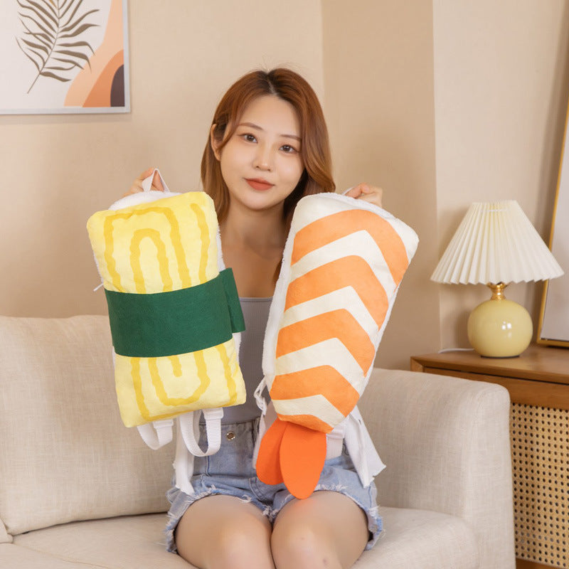 Two plush sushi backpacks: yellow egg with a green seaweed band and white-and-orange striped shrimp with or...