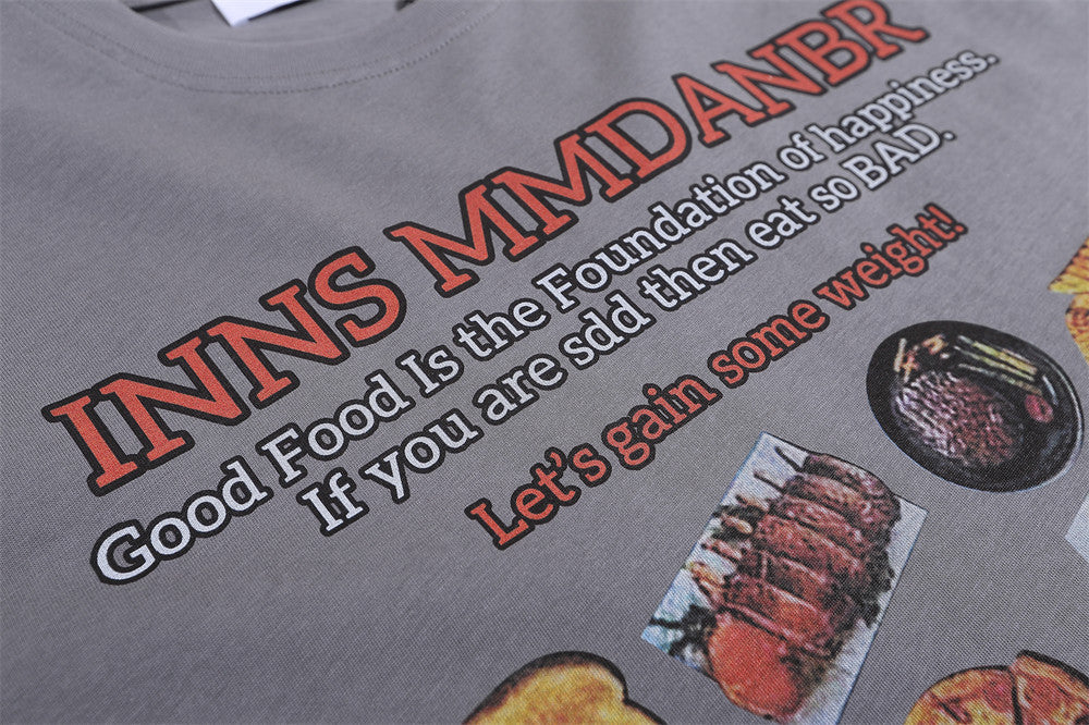 Grey T-shirt featuring a playful BBQ food print with humorous text about enjoying food and gaining weight.