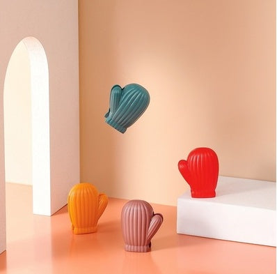 Four ribbed mitten-shaped bag clips in teal, red, orange, and mauve displayed on a peach backdrop.