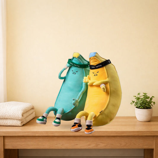 Yellow and mint green banana man plush toys sitting on a light oak bench