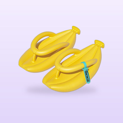 Pair of yellow banana flip flops with a teal toe strap tag, on a soft lilac background