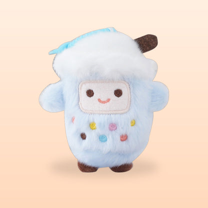 Blueberry bubble tea cup plush keychain, pale blue and fluffy with a smiley face, on a peach background