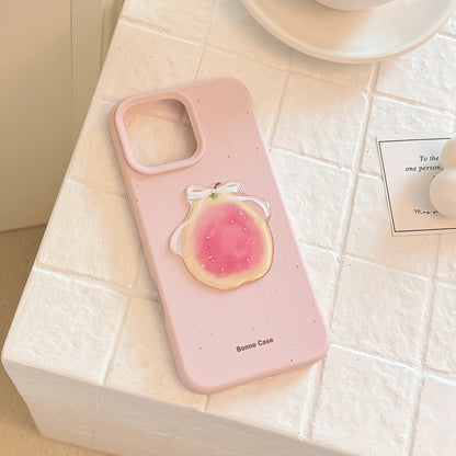 Pink 3D fruit silicone iPhone case featuring a glossy peach design with a white ribbon detail.