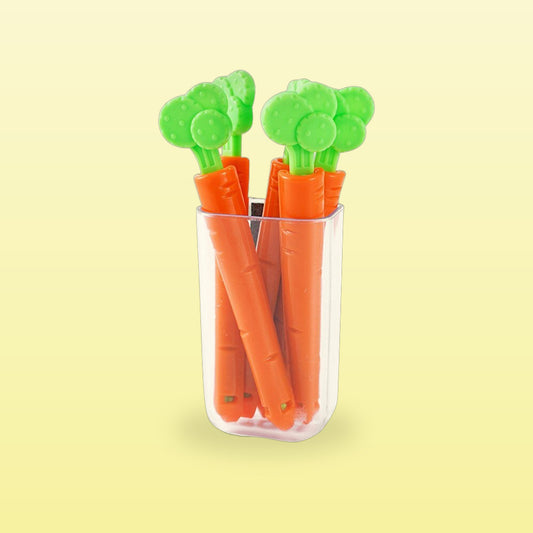 Carrot shaped magnetic food clips standing in their clear holder, on a butter yellow background