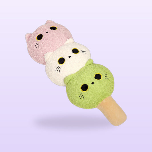 Cat dango plush pillow with wide eyed pink, white and matcha green cat heads, on a soft lilac background