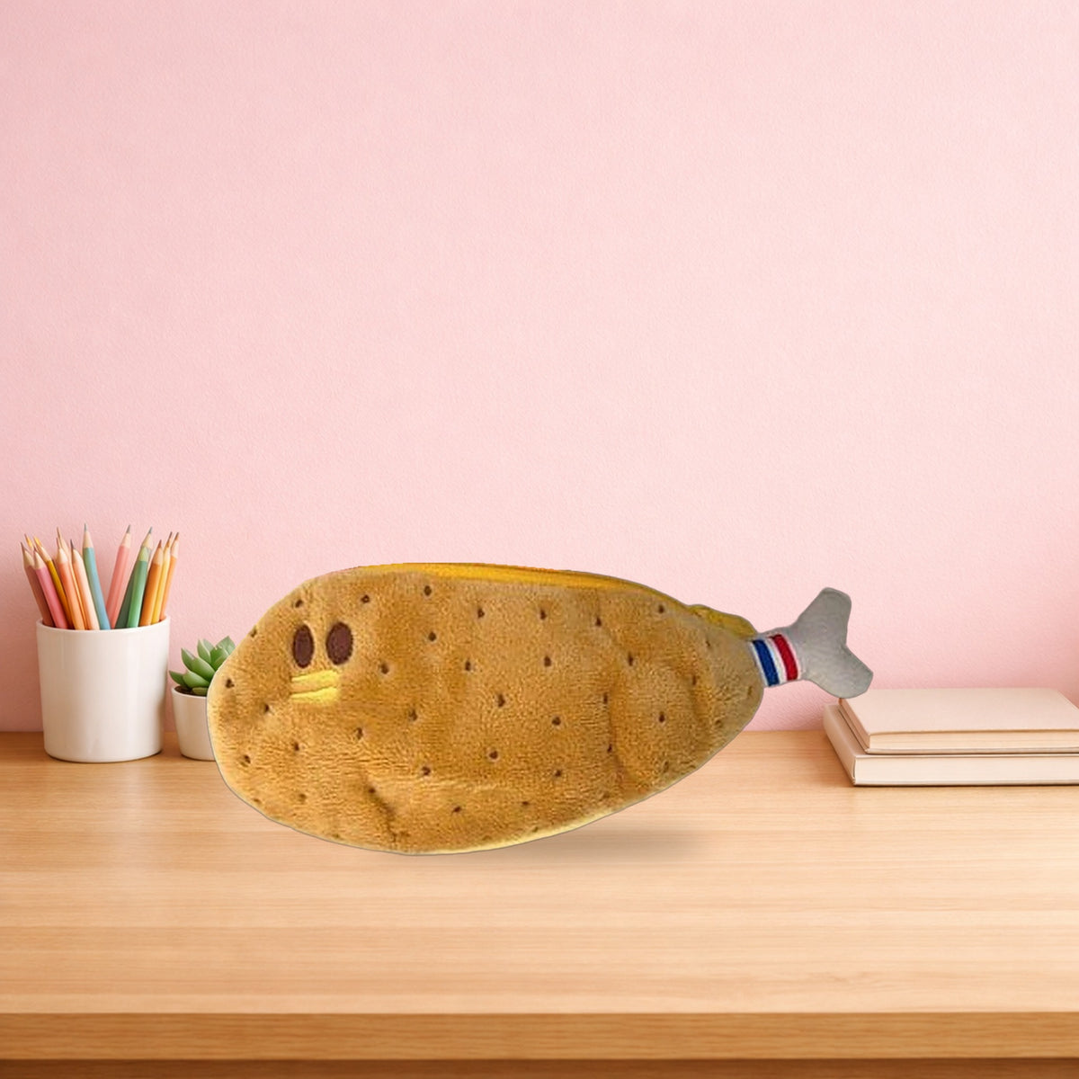Chicken leg plush pencil case on a light oak desk