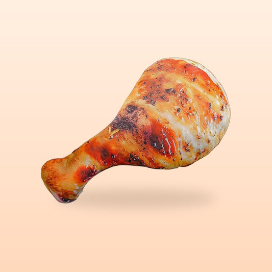 Chicken drumstick plush pillow with a grilled barbecue print, on a peach background