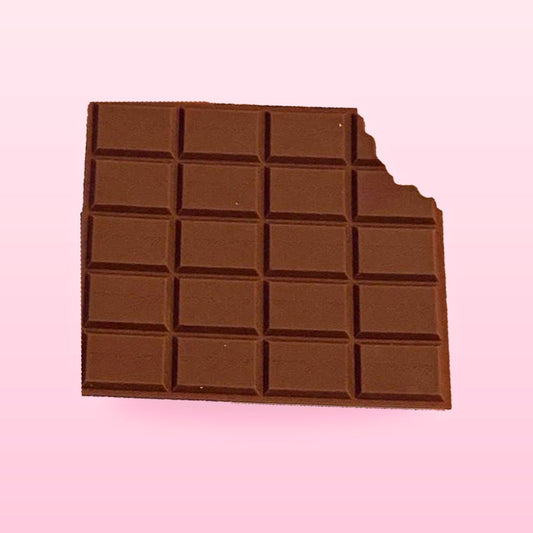 Chocolate bar scented memo pad with a bite out of one corner, on a pastel pink background