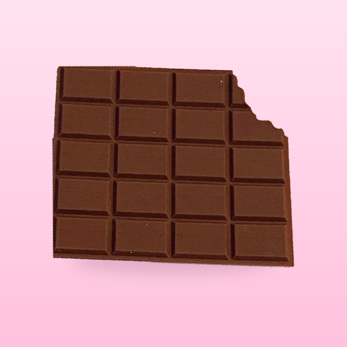 Chocolate bar scented memo pad with a bite out of one corner, on a pastel pink background