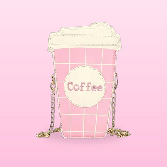 Pink coffee cup crossbody bag with a cream lid and gold chain strap on a pink background